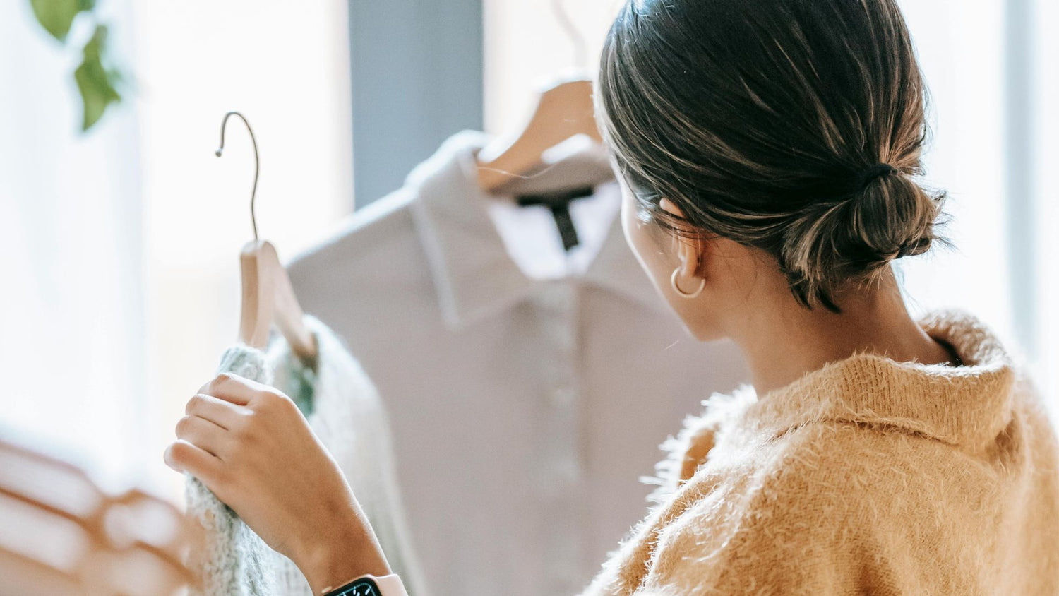 Woman holding clothes on clothes hanger